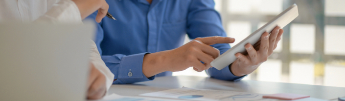 Deux personnes examinent des documents et une tablette pour évaluer l’admissibilité au programme de mesures de rechange au Québec.