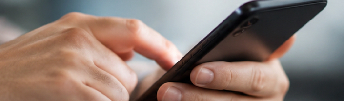 Mains écrivant un message sur un téléphone mobile, illustrant une communication directe interdite par une ordonnance de non-communication.