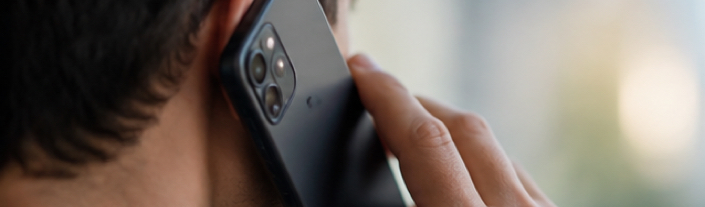 Homme passant un appel téléphonique avec son smartphone, risquant un bris de condition en cas d'interdiction de contact.